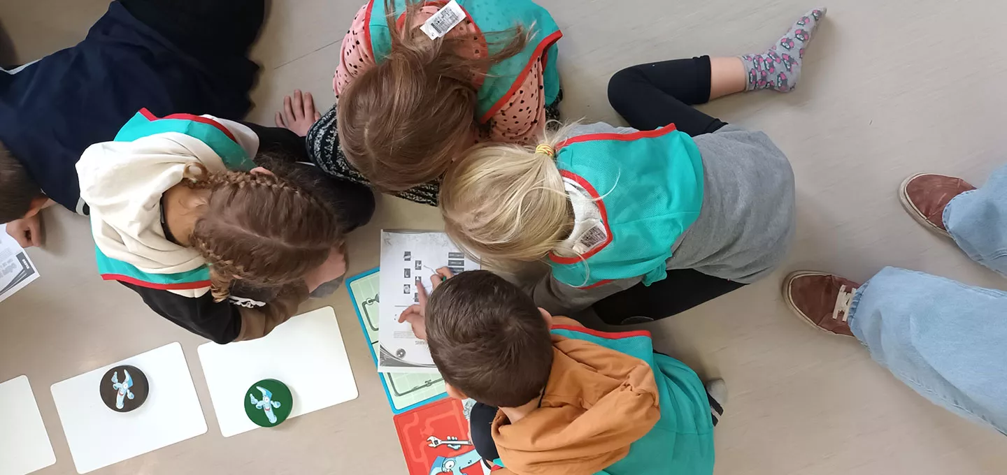 Enfants réunis autour du jeu Gaspido pour apprendre les gestes économes en eau, dans le cadre du programme ÉcoDrôme.